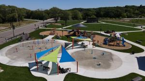 Families enjoying beautiful new park with Splashpad, playground, shade and shelter.